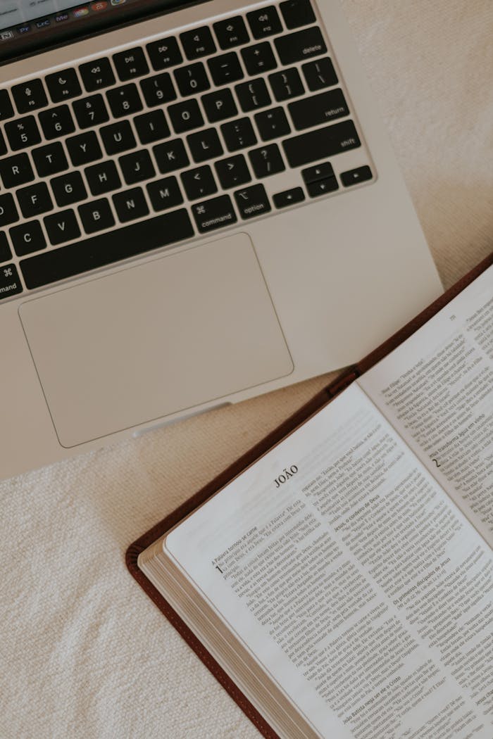 An open Bible beside a laptop, suggesting a blend of technology and spirituality.